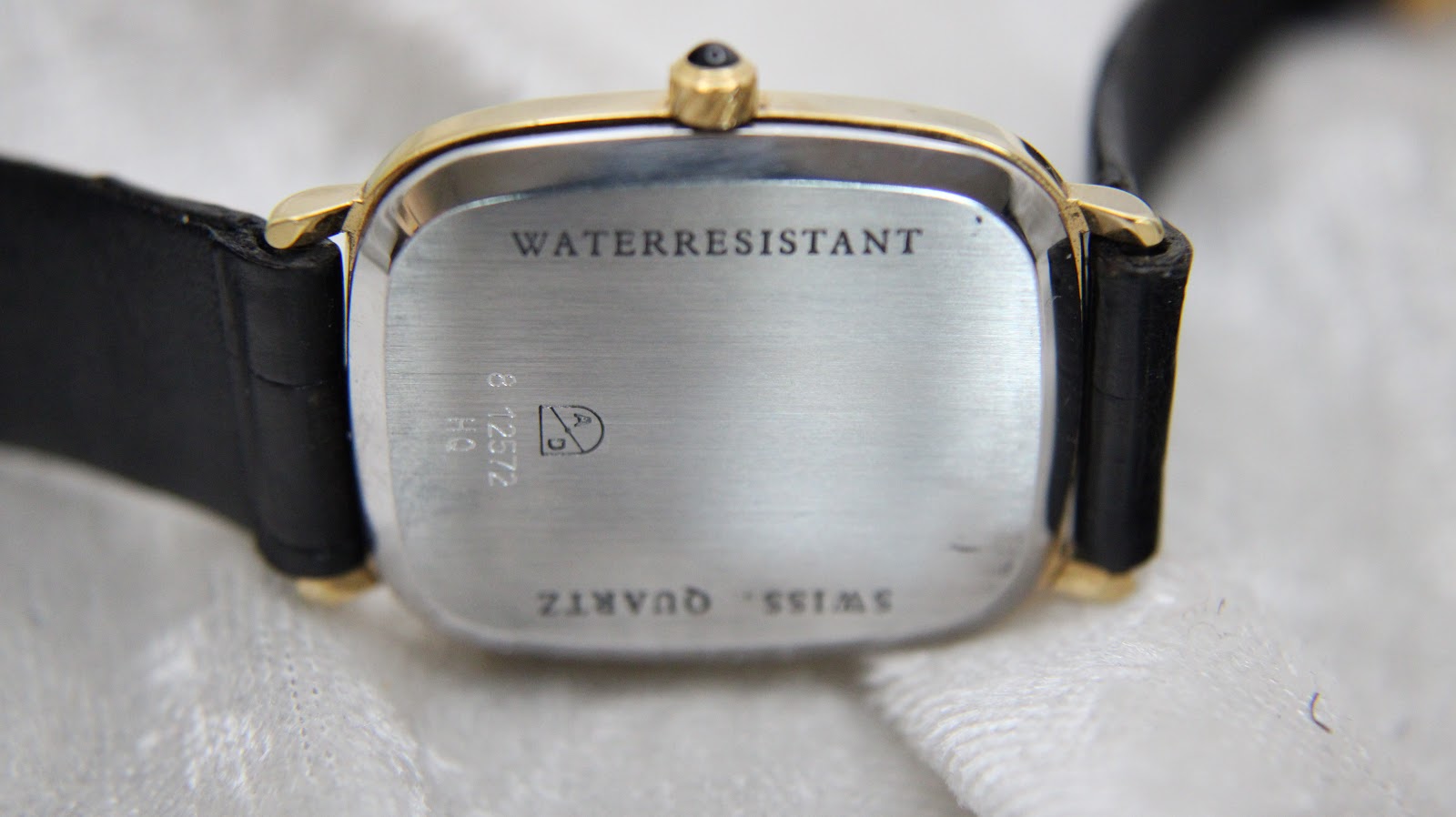 View of the brushed stainless steel case back, showing "WATERRESISTANT" and "HQ 812572" engravings.