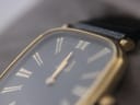 Close-up view of the watch dial and crystal, showing small hairline scratches on the glass.