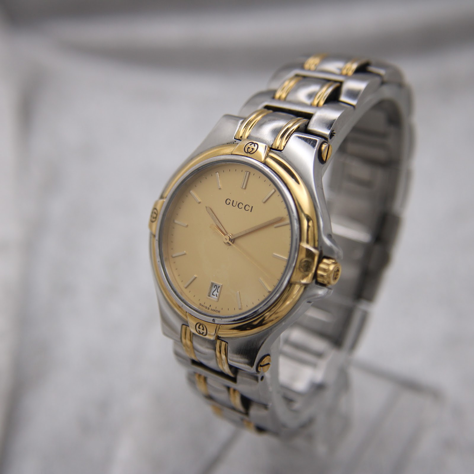 Detailed front-angled view of the Gucci 8040M, highlighting the two-tone bracelet and dial.