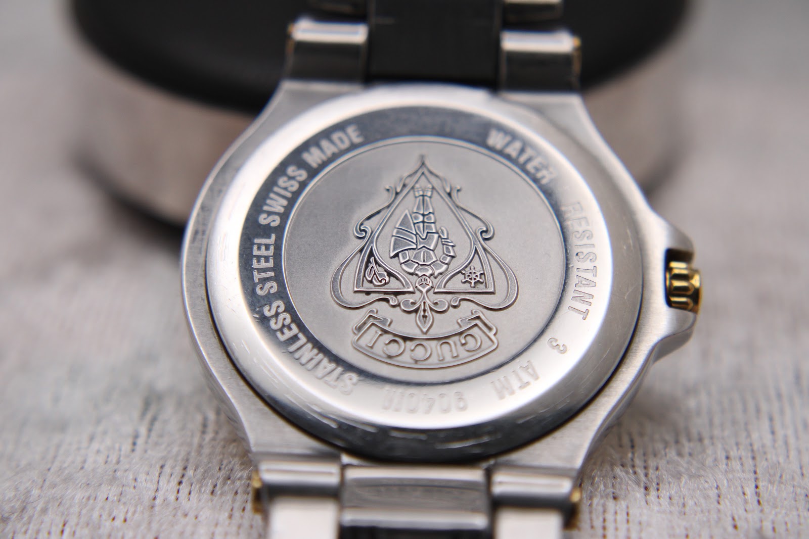 Rear view of the Gucci 8040M case back, displaying the embossed Gucci crest and engravings.