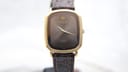 Front view of gold electroplated Raymond Weil 9517 quartz watch with dark brown sunburst dial and brown leather strap.