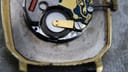 Very close-up of the quartz movement within the case, showing the battery and partial calibre number '950 001'.