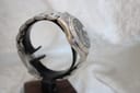Opposite side view of the Seiko watch on a display stand, showing the case profile and bracelet links.