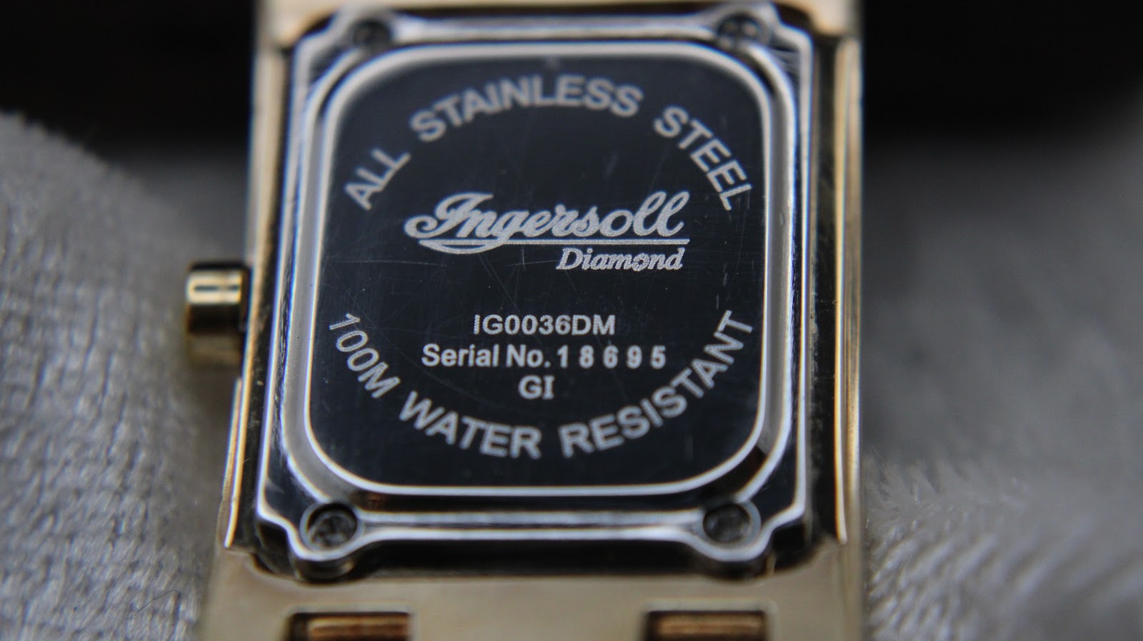 Detailed view of the watch case back, engraved with Ingersoll, model IG0036DM, serial number, and water resistance details.