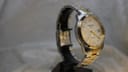 Side profile of the Tissot PR 100 showing its two-tone case and crown detail.