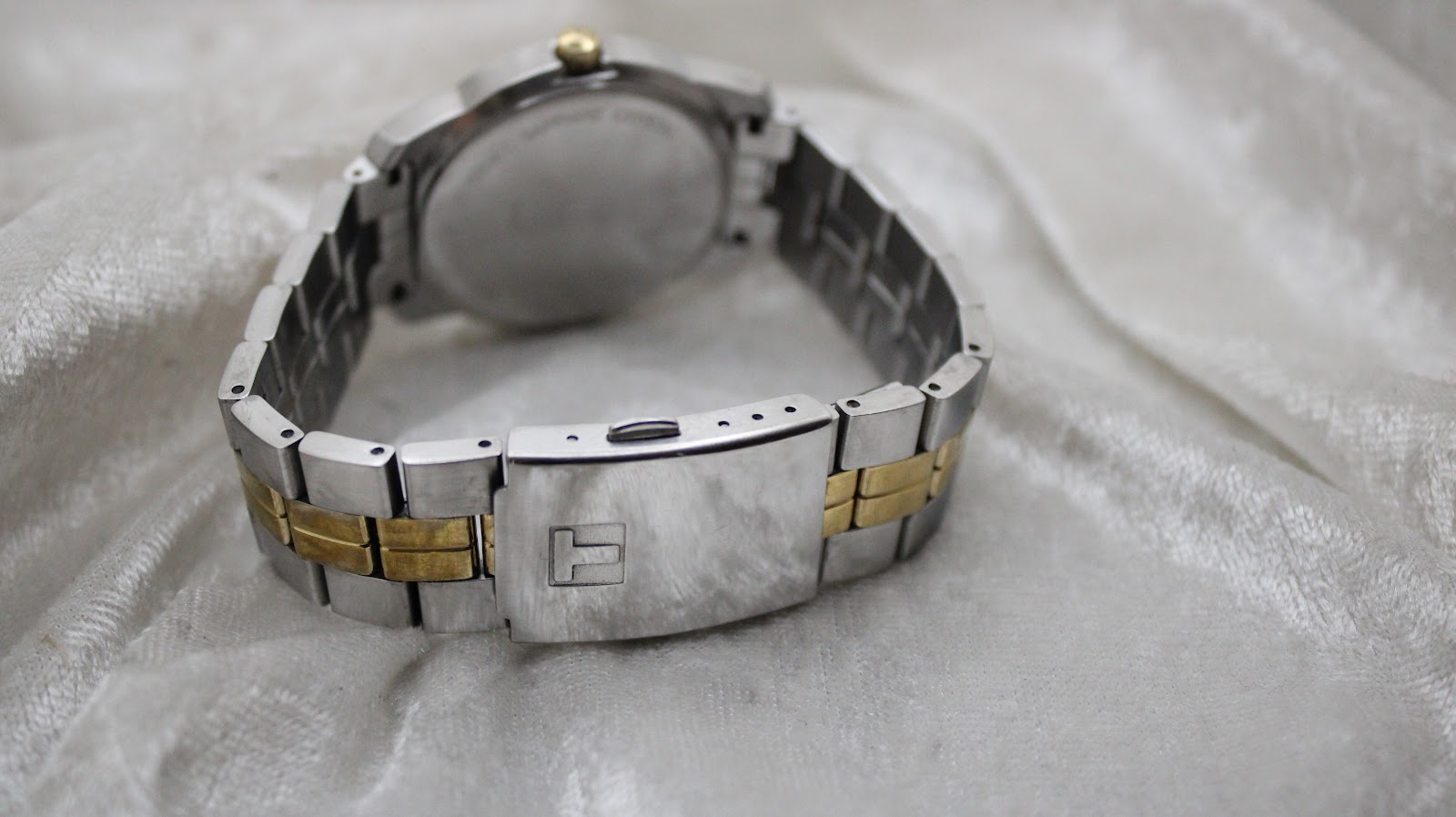 Detailed view of the Tissot PR 100 silver sunburst dial with date window at 3 o'clock.