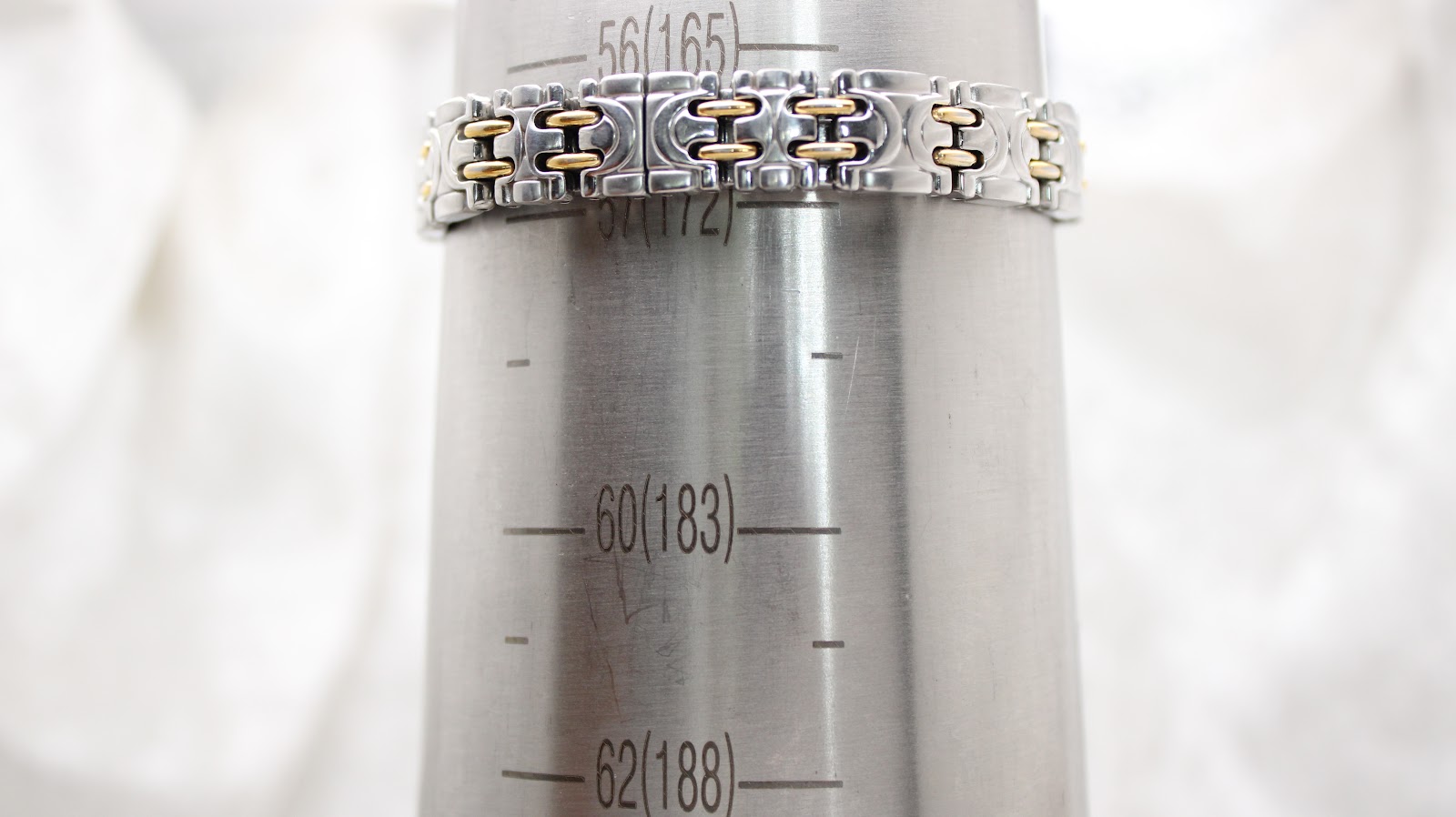 The two-tone watch bracelet on a metal wrist sizing gauge, showing a circumference measurement of approximately 170mm (around the 56-58 mark).
