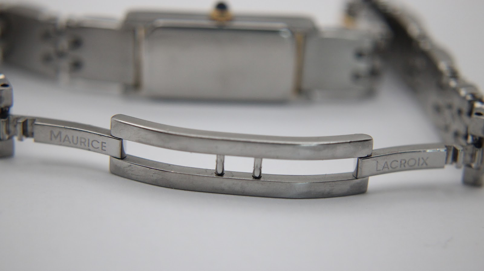 Close-up of the deployant clasp, clearly showing 'Maurice Lacroix' engraved on the polished stainless steel links.