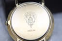 Detailed view of the watch case back, featuring the engraved Gucci crest, '3000 M' model number, and serial number.