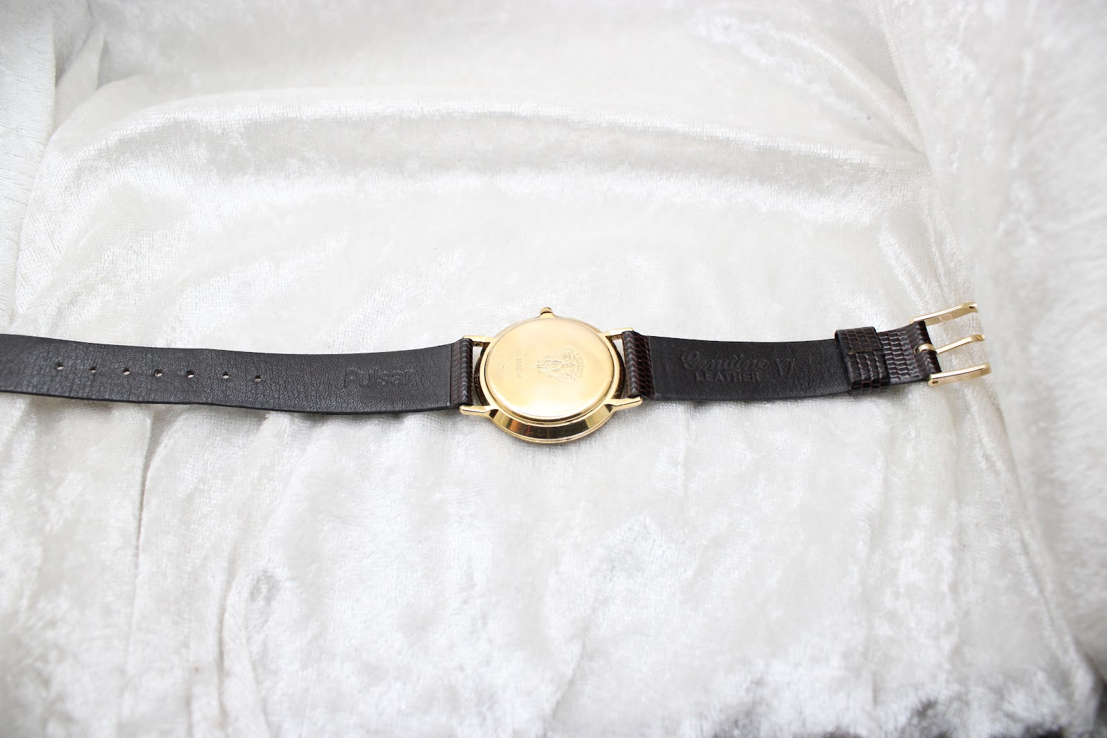 Full length top-down view of the Gucci 3000M watch on its brown leather strap, showing the case back.