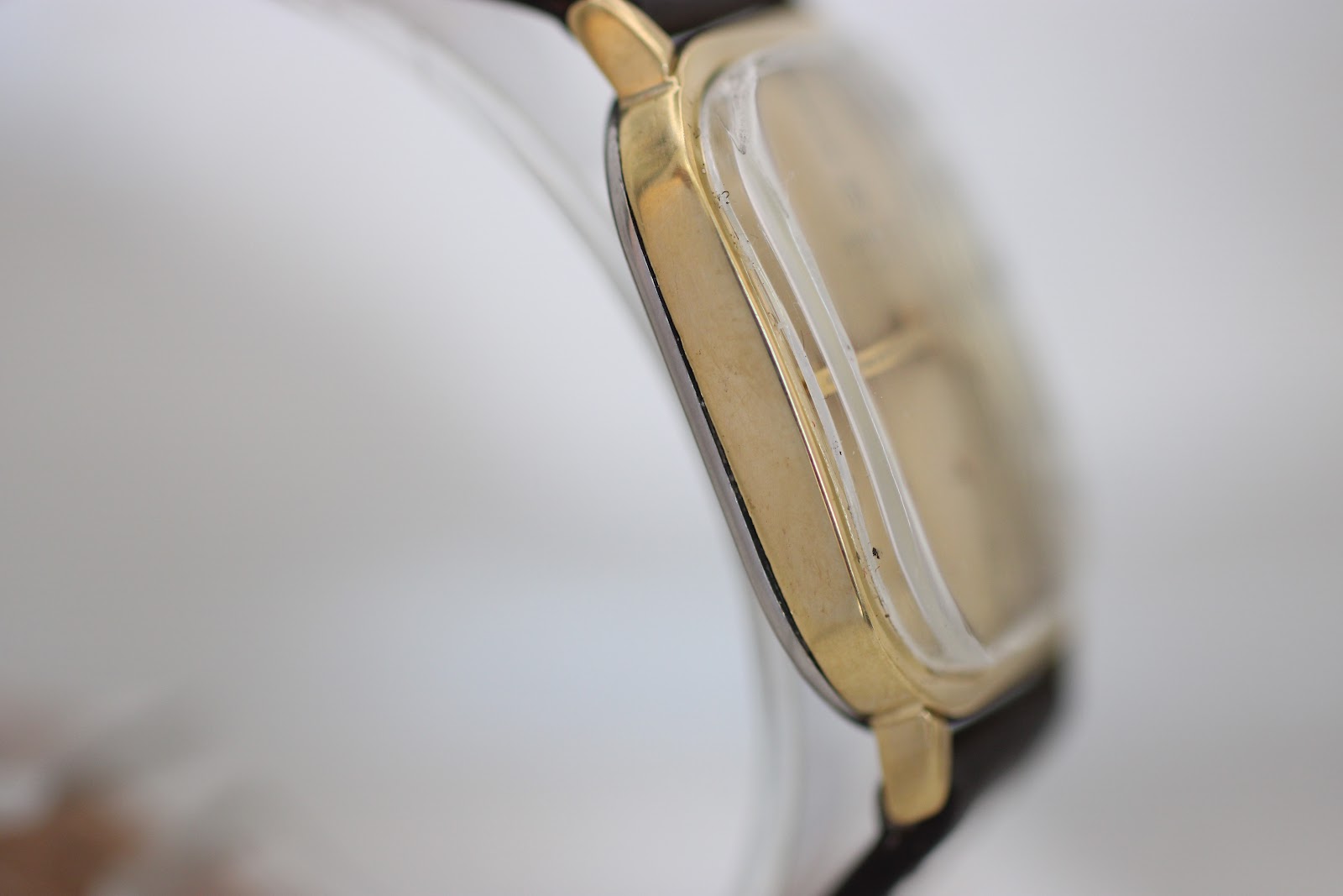 Side profile of the gold-tone Junghans watch case, highlighting its thinness and curved edges.