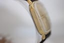 Side profile of the gold-tone Junghans watch case, highlighting its thinness and curved edges.
