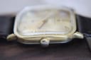 Top-down view of the watch showing the gold-tone crown and the square case shape.