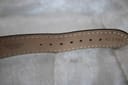 Close-up of the black leather strap's underside, showing 'Genuine Calf' text and strap holes.