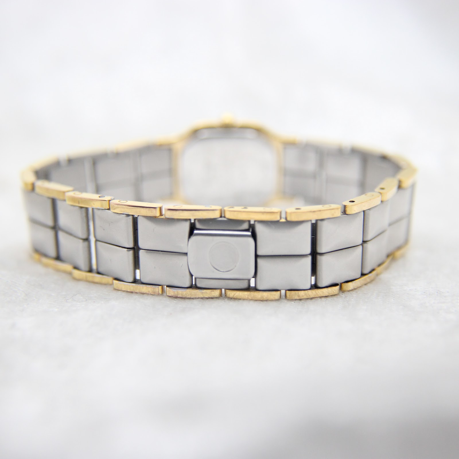 Rear view of the integrated two-tone metal bracelet with the hidden folding clasp closed.