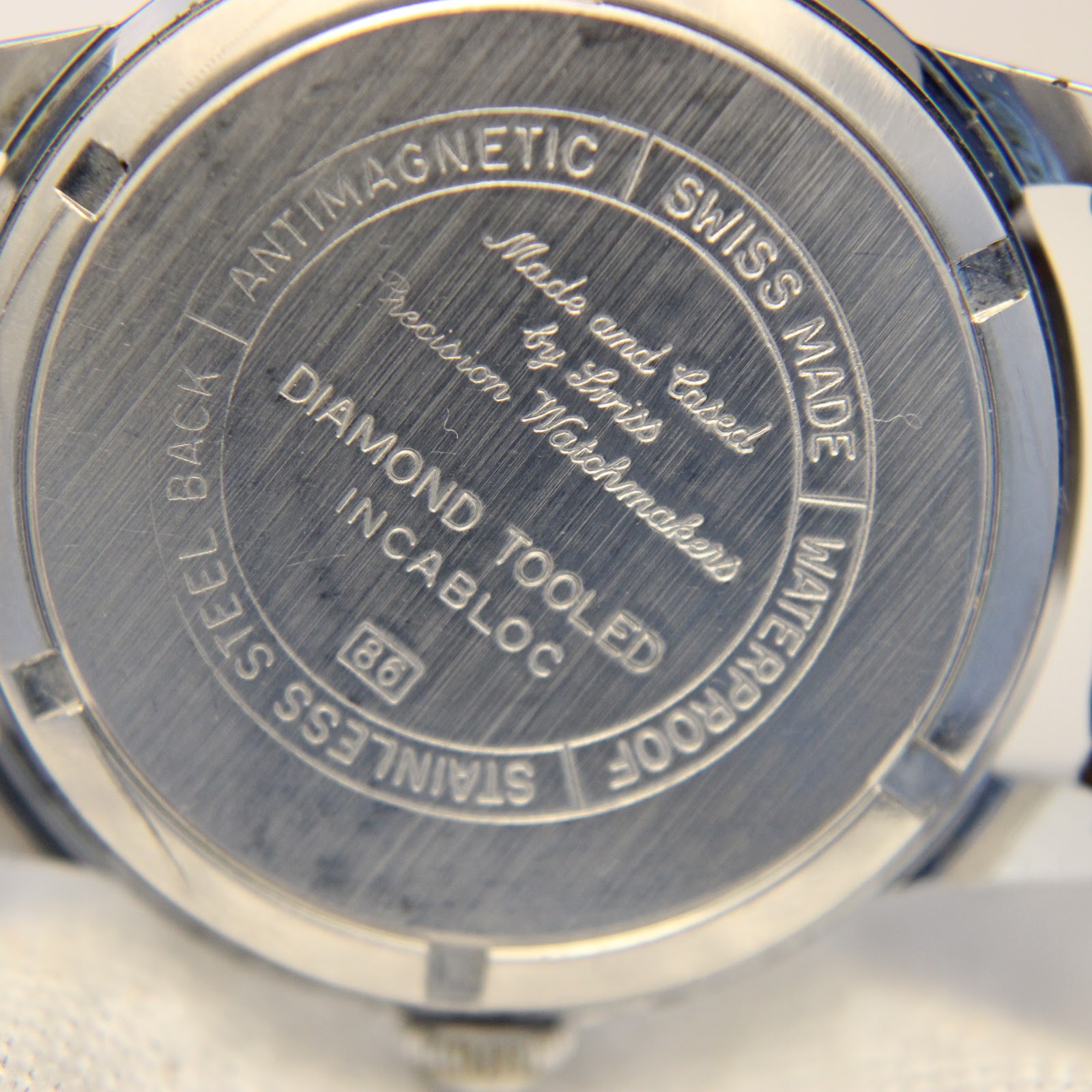Engraved stainless steel case back of Allaine watch, 'Swiss Made' inscription