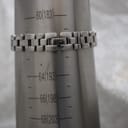 Close-up of the Tissot G330's integrated bracelet and signed butterfly clasp on a wrist sizing gauge, indicating a fit of 183mm.
