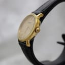 Detailed view of the champagne dial, Tissot logo, and gold baton hour markers.