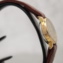 Close-up of the Tissot watch's brown leather strap and classic buckle.