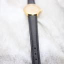 Close-up focus on the black leather strap of the Tissot watch, showing its texture and stitching.