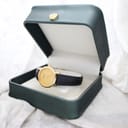 The Tissot C225K watch displayed inside an open, dark green presentation box with a golden crown emblem on the lid.
