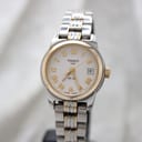 Front view of the Tissot PR 50 women's watch with white dial, gold-tone Roman numerals, and two-tone bracelet.