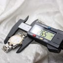 Digital caliper measuring the Tissot PR 50 watch case diameter at 26.5mm, excluding the crown.