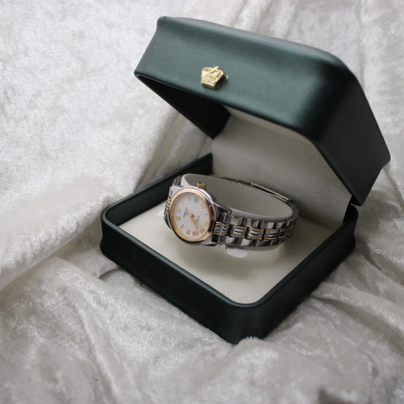 The Tissot PR 50 watch displayed inside a green generic watch box.