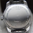 Detailed view of Tissot PR 100 silver dial, Roman numerals, and minute track.