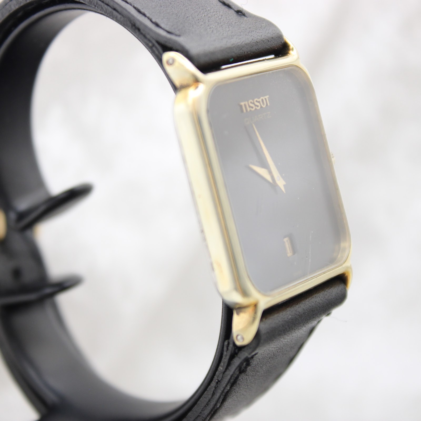 Close-up of the black leather replacement strap with its buckle.