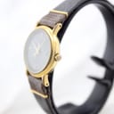 Side profile of the Tissot Stylist watch, highlighting its slim gold-tone case and crown details.