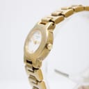 Angled view of the Tissot G331K gold watch, showing the right side of the case, crown, and integrated bracelet.