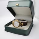 The Tissot Stylist watch displayed inside a green watch box with a gold crown emblem.