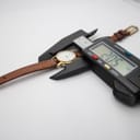 Overhead view of the Tissot watch with a digital caliper measuring the case diameter at 20.5mm, confirming the watch's small size.