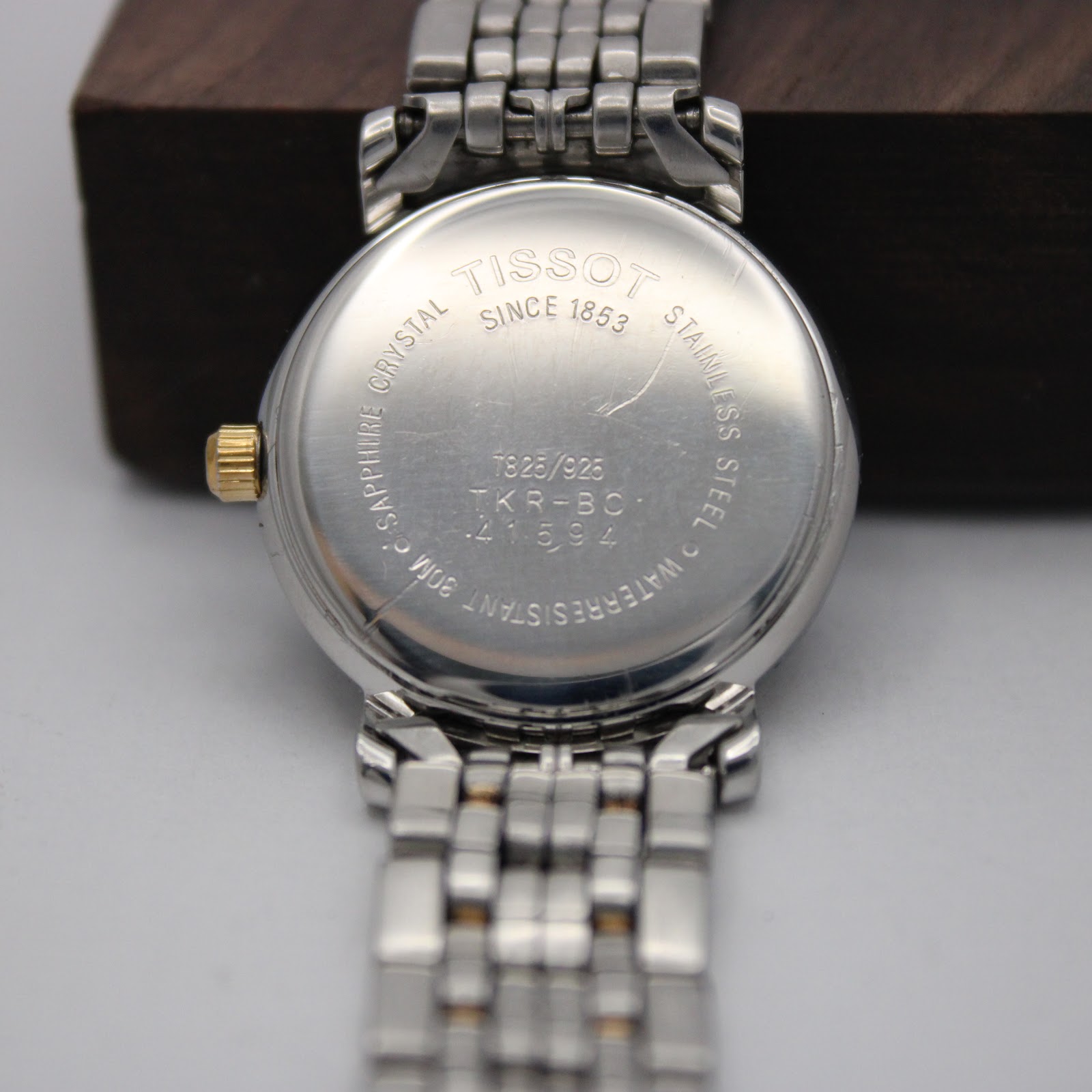 Close-up of the stainless steel case back, engraved with "TISSOT SINCE 1853", model reference T 825/925, "SAPPHIRE CRYSTAL", "WATERRESISTANT 30M", and serial number.