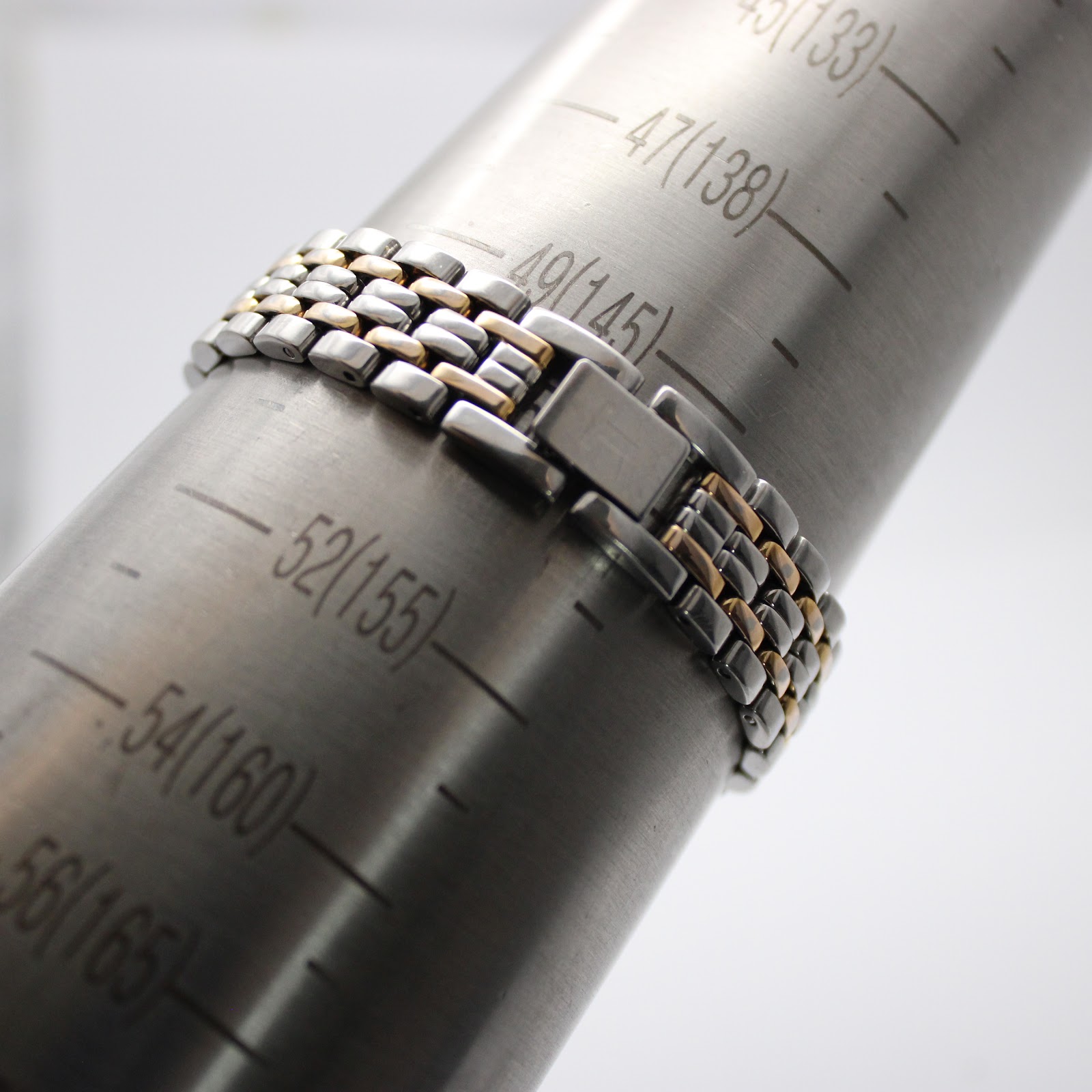 The watch bracelet closed around a wrist sizing gauge, showing a fit for approximately 150mm (15cm) wrist circumference.