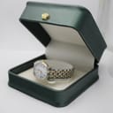 The Tissot 1853 watch resting inside an open, dark green presentation box with a cream interior.