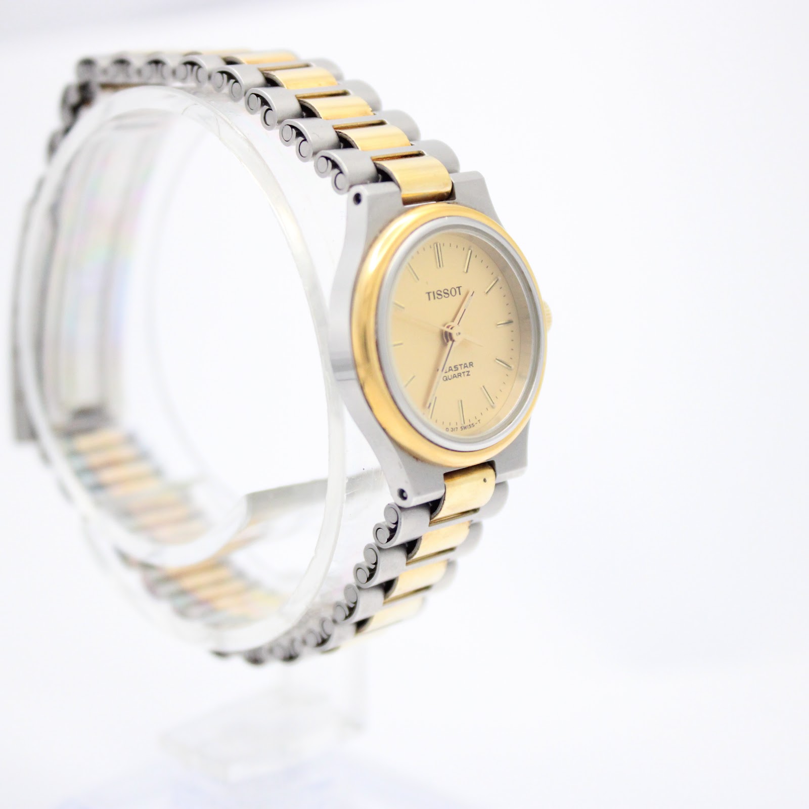 Alternate angled side view of the Tissot Seastar, showcasing the design of the bracelet links and the overall elegant profile on a clear stand.