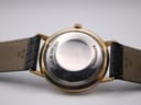 Black leather strap with gold-tone Tissot signed buckle.