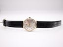 Rear view of stainless steel case back and black leather strap.
