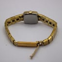 Rear view of the watch showing the stainless steel case back and the integrated bracelet with open clasp.