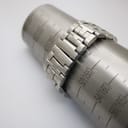 Tissot stainless steel bracelet wrapped around a wrist sizing gauge, showing a fit of approximately 150mm / 15cm, with a signed Tissot clasp visible.