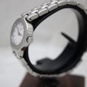 Side profile view of the Tissot G334 watch on a stand, highlighting the stainless steel case and the T-logo etched crown.