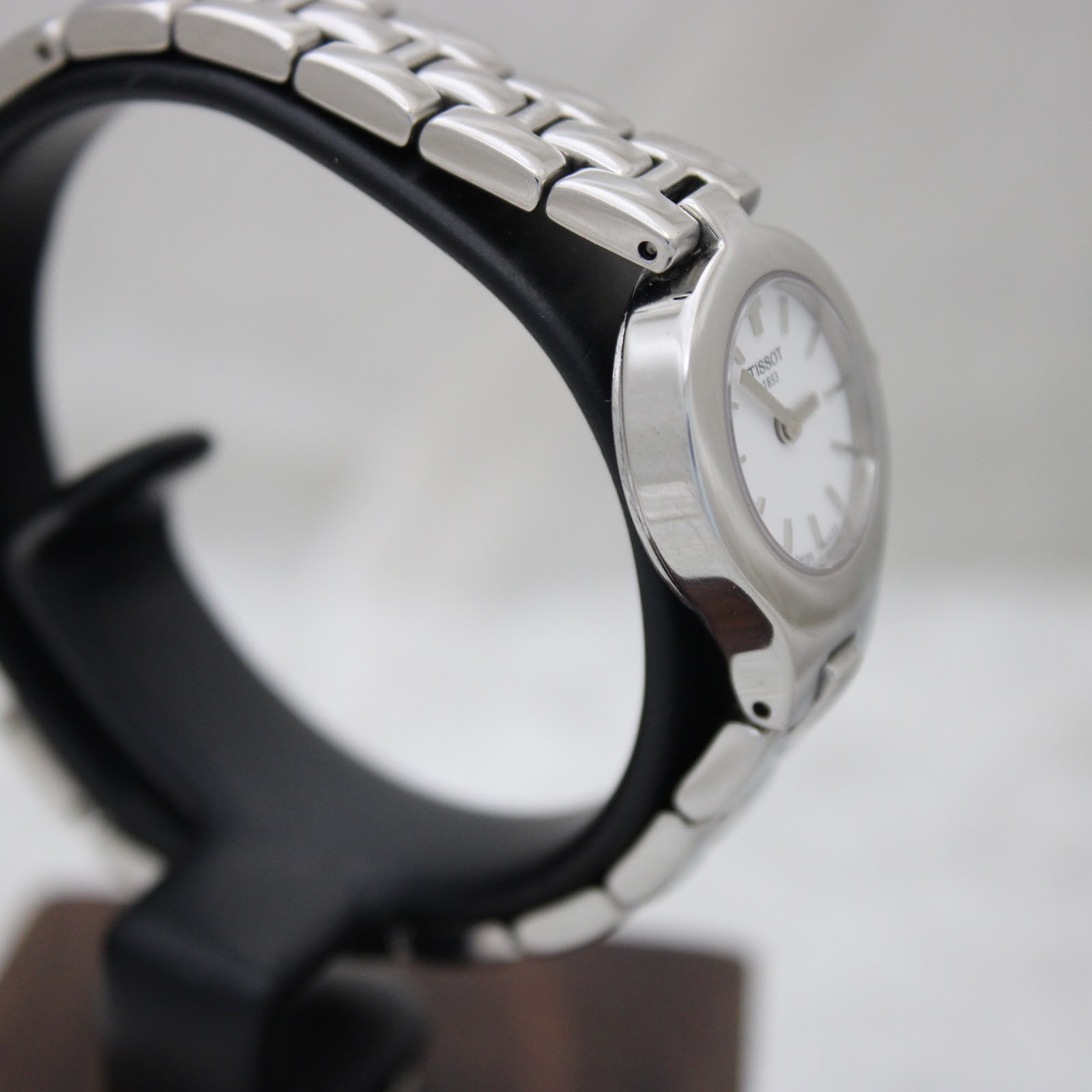 Angled side view of the Tissot G334 watch, showing the integrated stainless steel bracelet design and the curvature of the case.