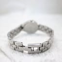 Rear view of the Tissot G334's integrated stainless steel bracelet with its folding clasp open, laid against a textured white background.