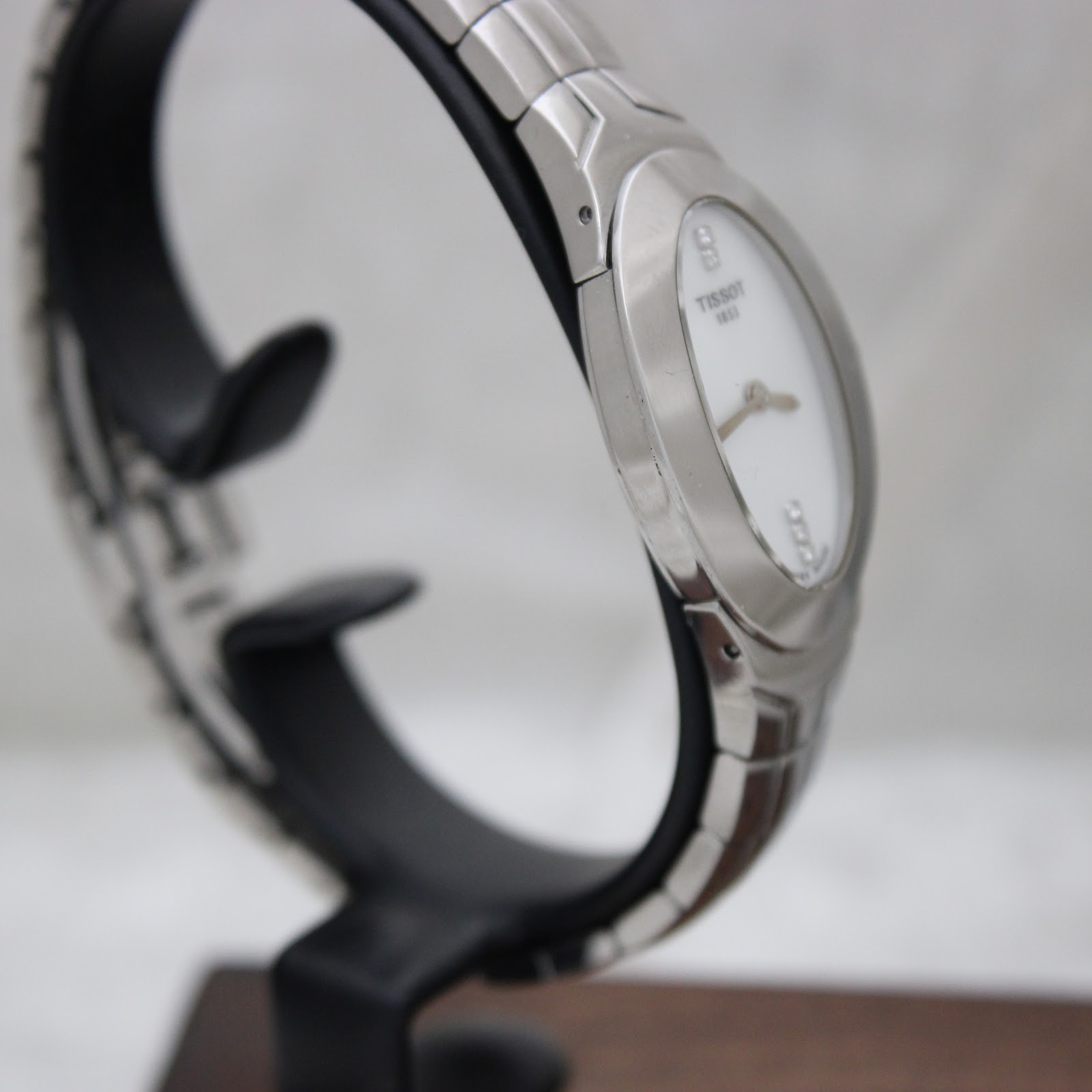 Angled side view of the Tissot L720 watch, highlighting the polished steel finish and sapphire crystal.