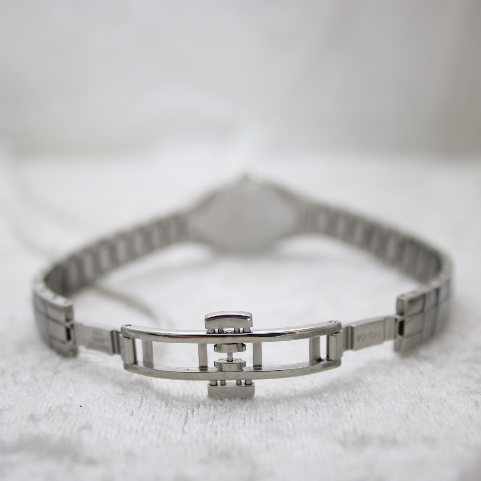 Close-up of the deployment clasp on the Tissot L720 stainless steel integrated bracelet.