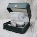 The Tissot L720 watch inside a green Tissot presentation box with an accompanying paper slip.