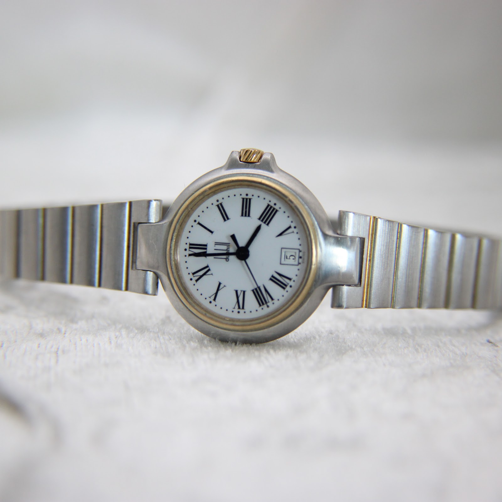 Front view of the Dunhill watch, laid flat, showing the full two-tone bracelet.