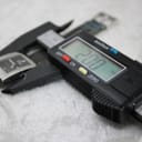 Digital caliper displaying 28.00 mm, measuring the length of the watch case.